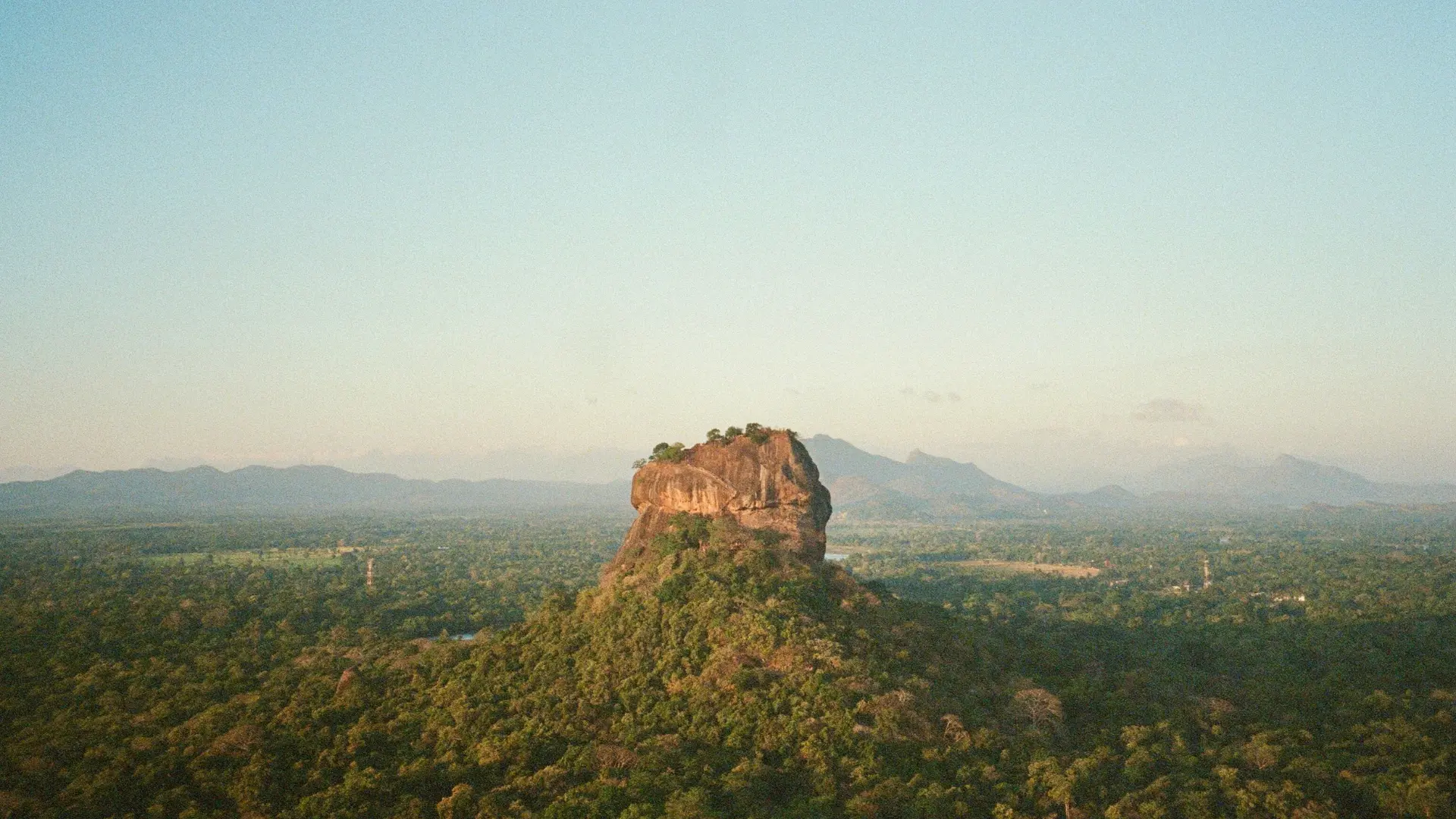 Sigiriya rock fortress rising above the Sri Lankan jungle at golden hour